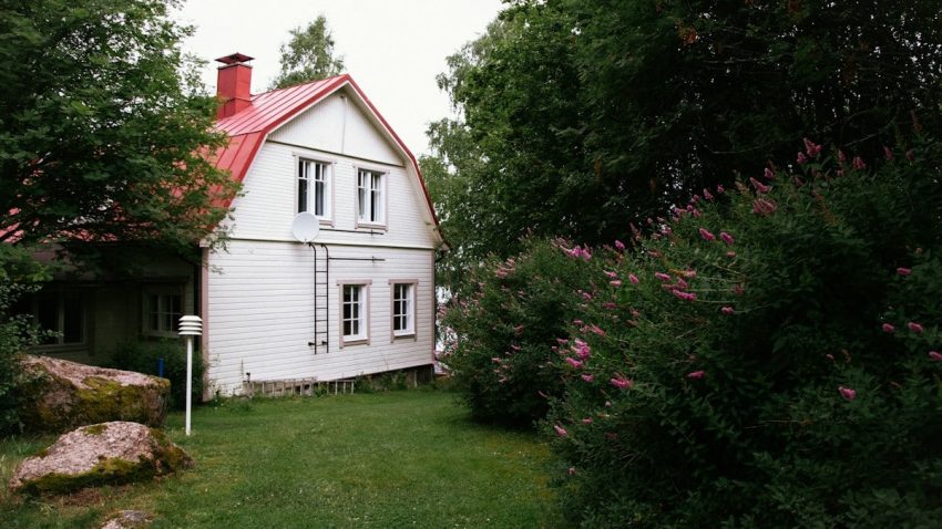 a house with a yard and bushes around it